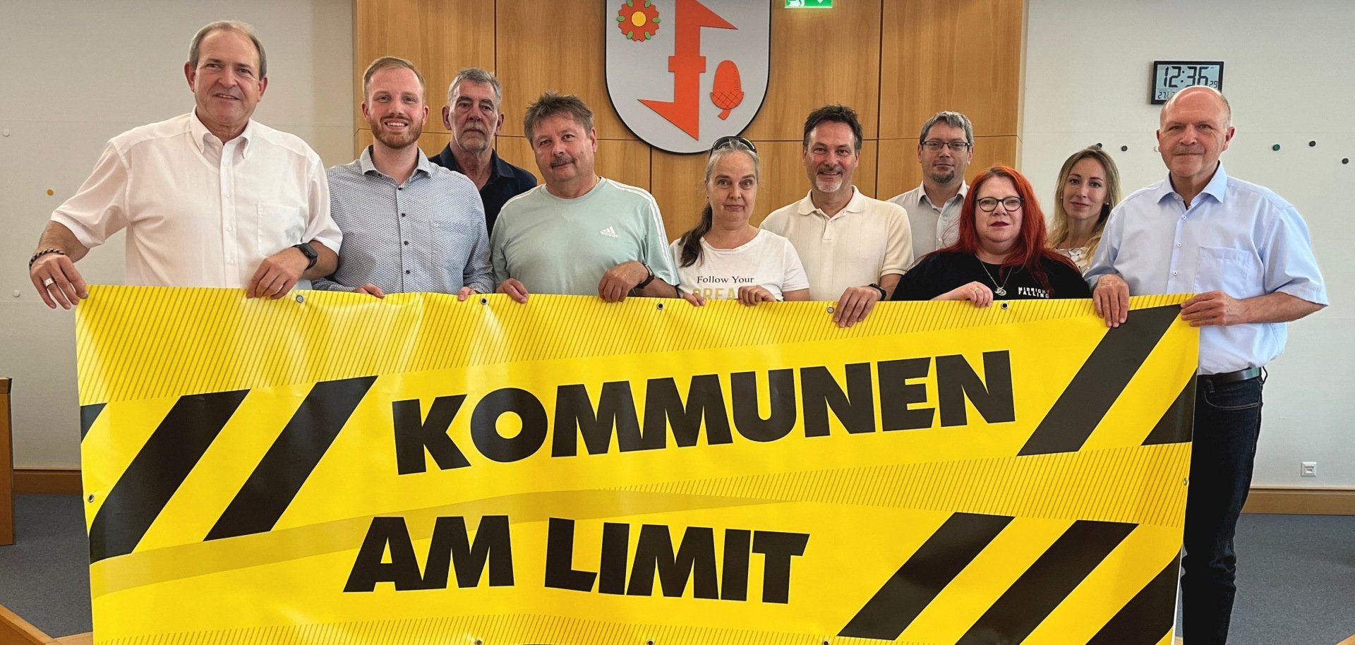 Das Foto zeigt die Teilnehmer des Pressegesprächs, die gemeinsam ein Banner mit der Aufschrift "Kommen am Limit" halten.