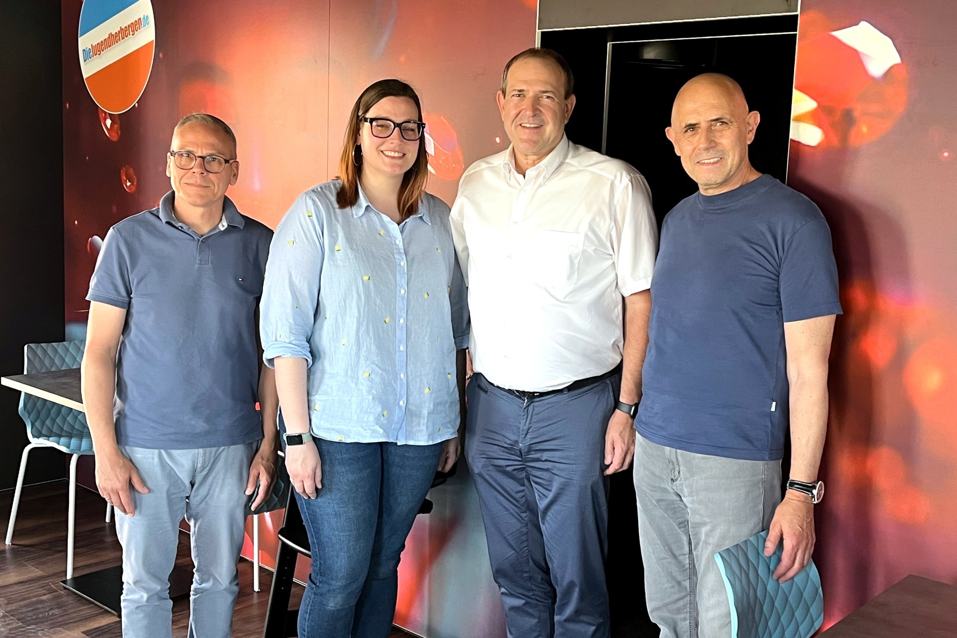 Das Foto zeigt die genannten Personen. Sie stehen nebeneinander im Restaurantbereich. Auf der Wand hinter Ihnen sind Edelsteine zu sehen.
