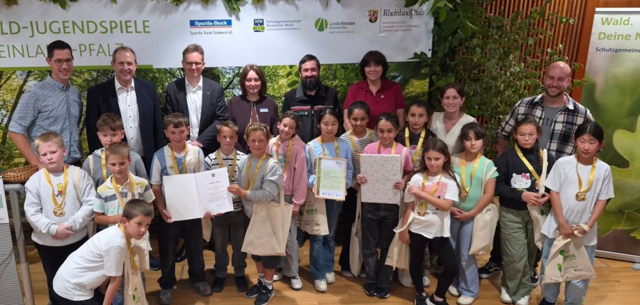 Die Schülerinnen und Schüler der GS Göttschied freuten sich über den Landessieg und die Urkunde von Oberbürgermeister Frank Frühauf. Das Foto zeigt die Schüler mit den Organisatoren der Veranstaltung sowie Begleitpersonen auf der Bühne.