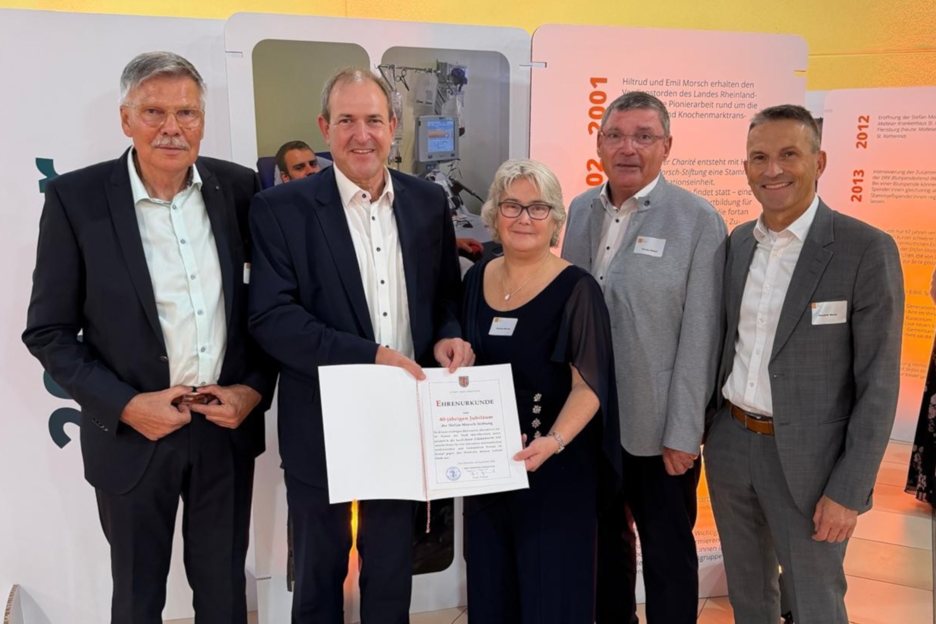 Das Foto zeigt OB Frühauf und vier weitere Personen von der Stefan-Morsch-Stiftung. OB Frühauf übergibt ihnen eine Urkunde der Stadt Idar-Oberstein.